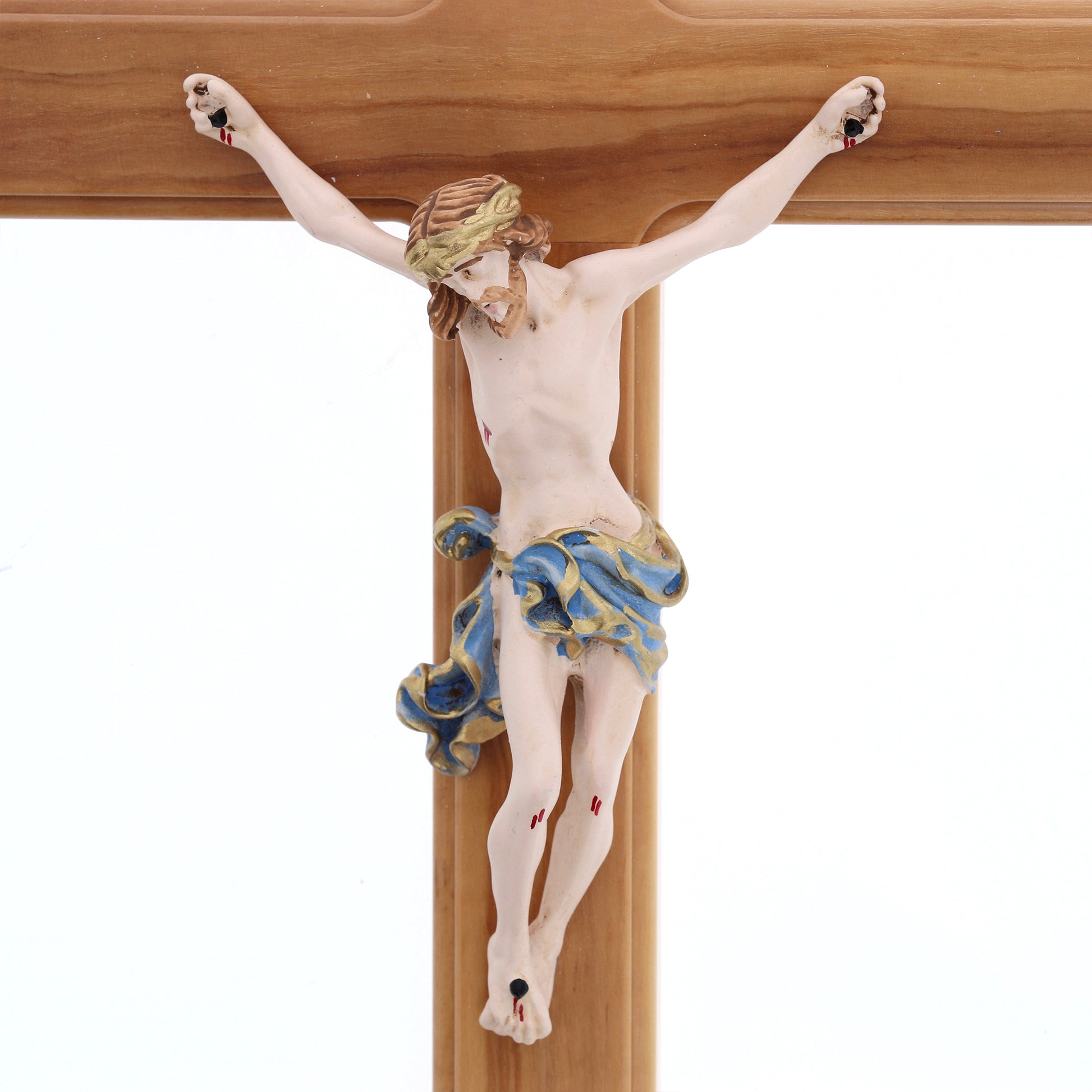 Crocifisso in legno d'olivo, corpo in resina decorata. Altezza 27 cm