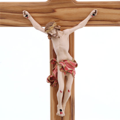 Crocifisso in legno d'olivo, corpo in resina decorata. Altezza 27 cm