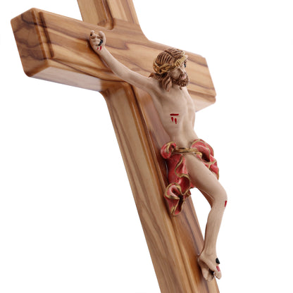 Crocifisso in legno d'olivo, corpo in resina decorata. Altezza 27 cm