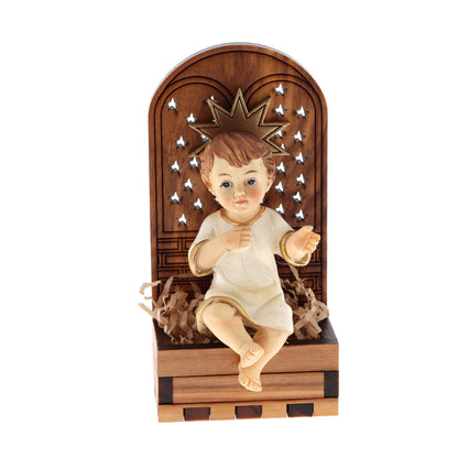 Base in legno d'olivo con stella in rilievo con Gesù Bambino seduto. Dimensioni 9,5x4,5 cm