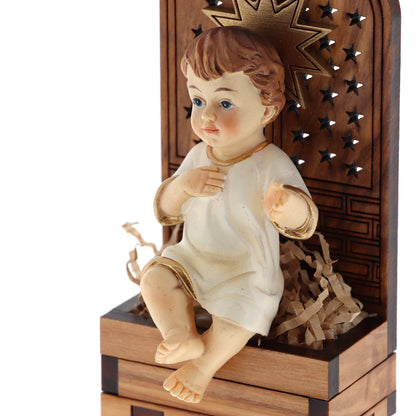 Base in legno d'olivo con stella in rilievo con Gesù Bambino seduto. Dimensioni 9,5x4,5 cm