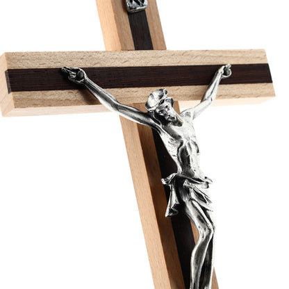 Crocifisso in legno chiaro con inserti in legno scuro e corpo in metallo. Altezza 20 cm